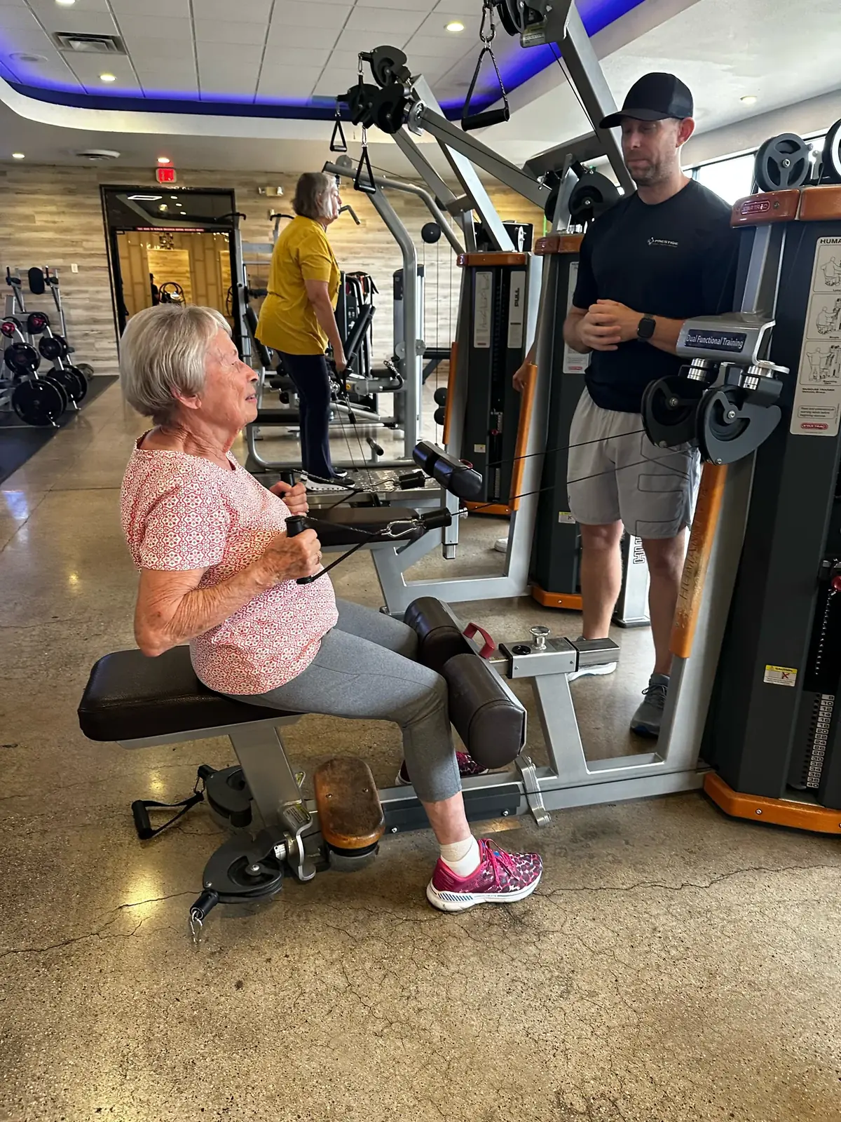 Adult client on a seated row with her Prestige coach in Tucson