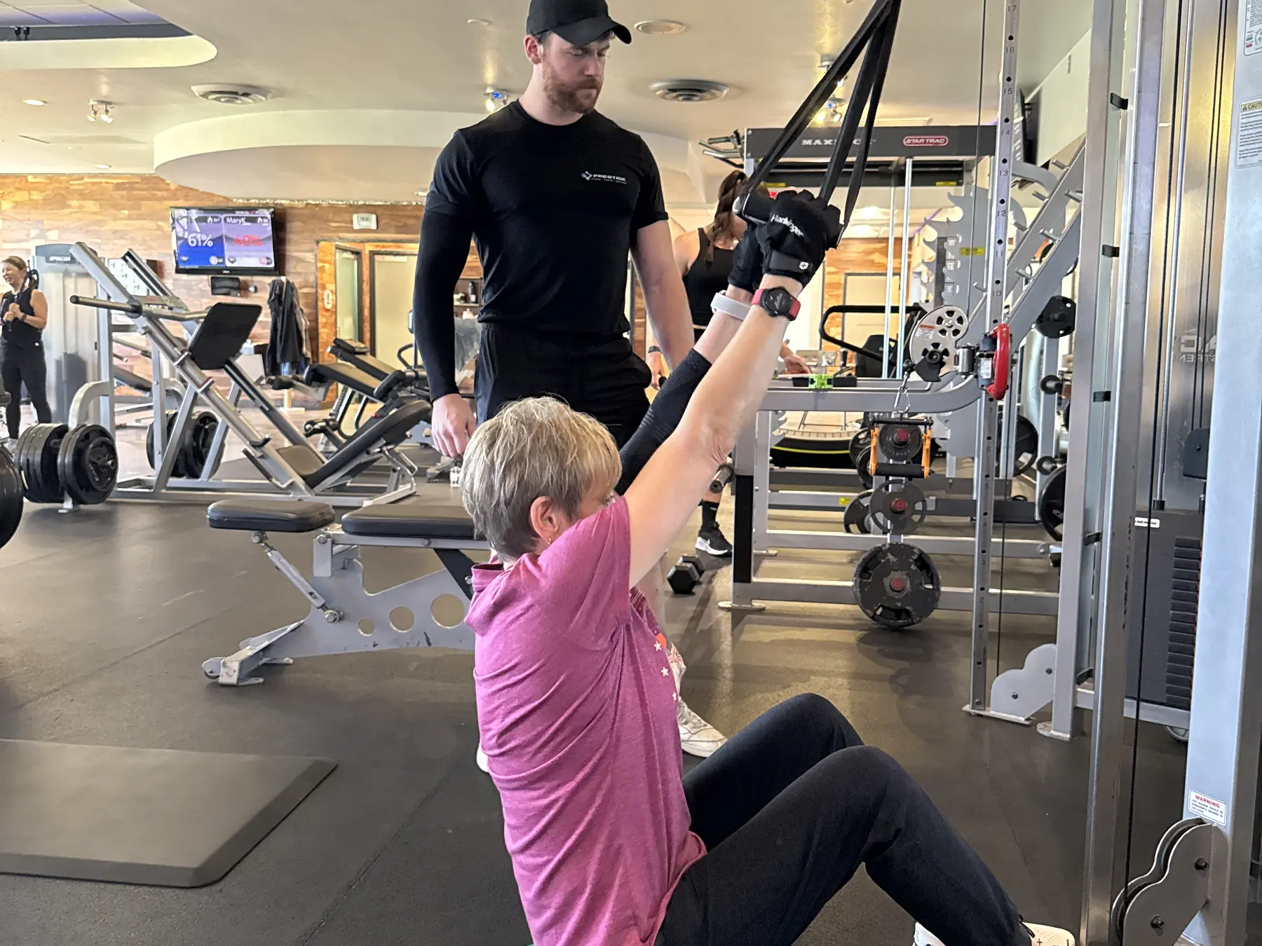A Prestige Fitness trainer observing a client and considering the next coaching decision