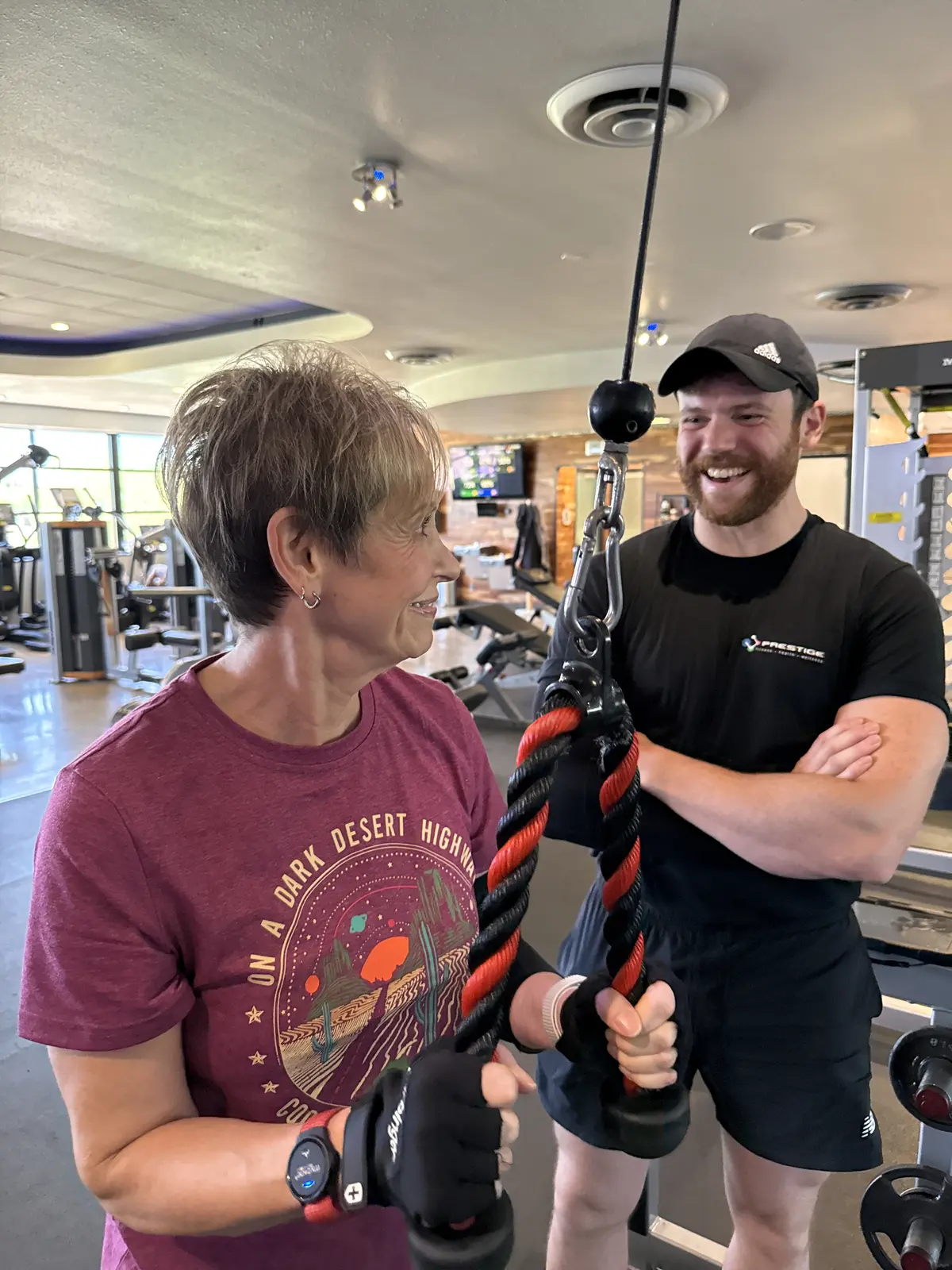 A Prestige Fitness coach guiding a client during a personal training session in Tucson
